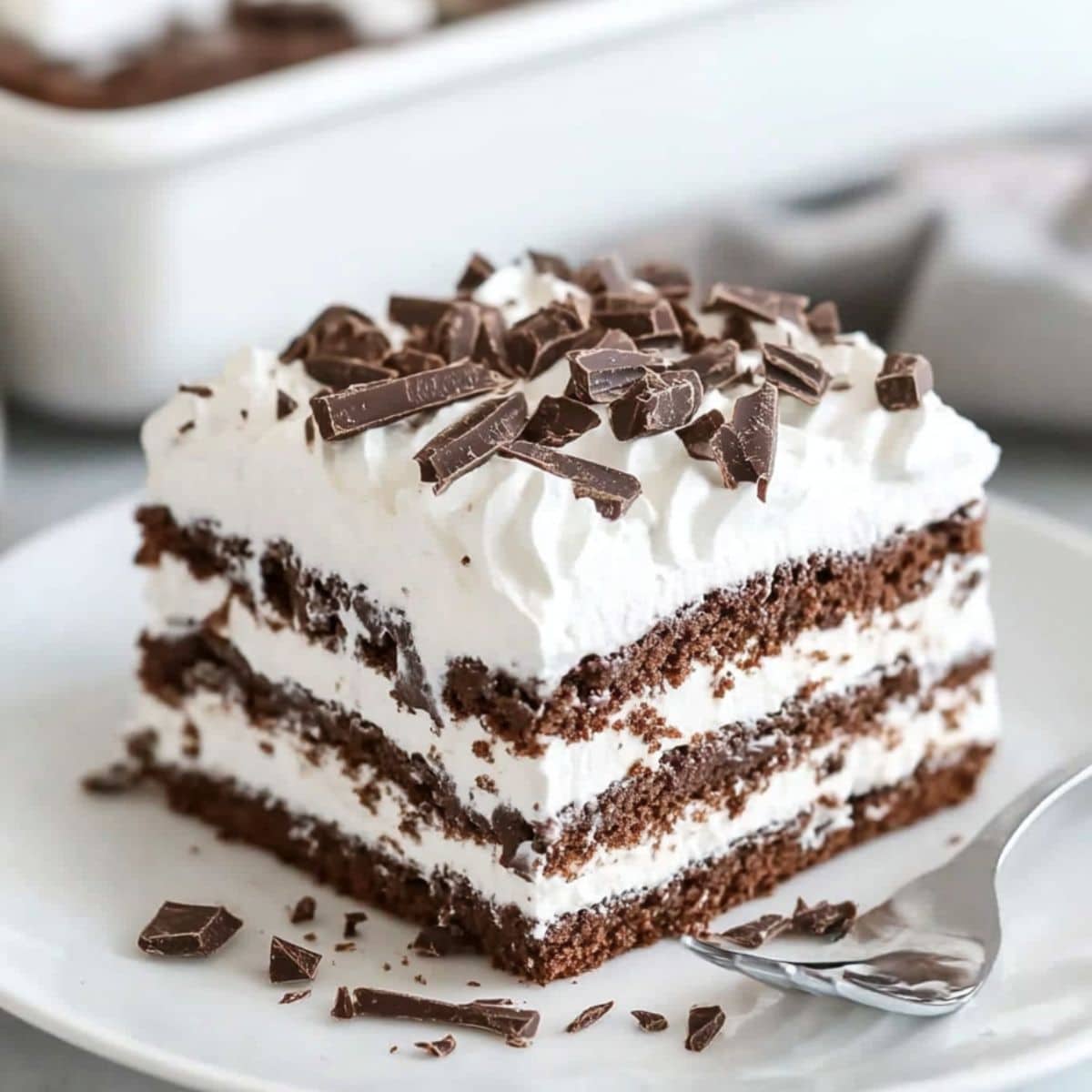 Square slices of chocolate icebox cake served in  a white plate.