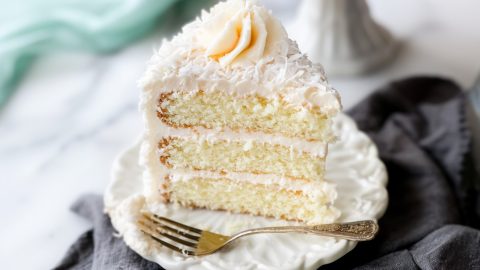 A coconut cake with a light, fluffy texture, topped with cream cheese frosting