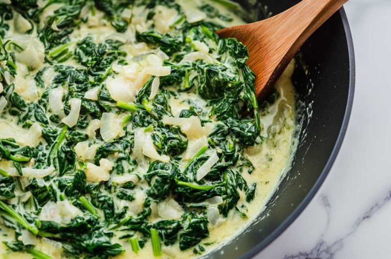 A hearty serving of creamed spinach with a creamy, buttery sauce and a touch of onions and garlic