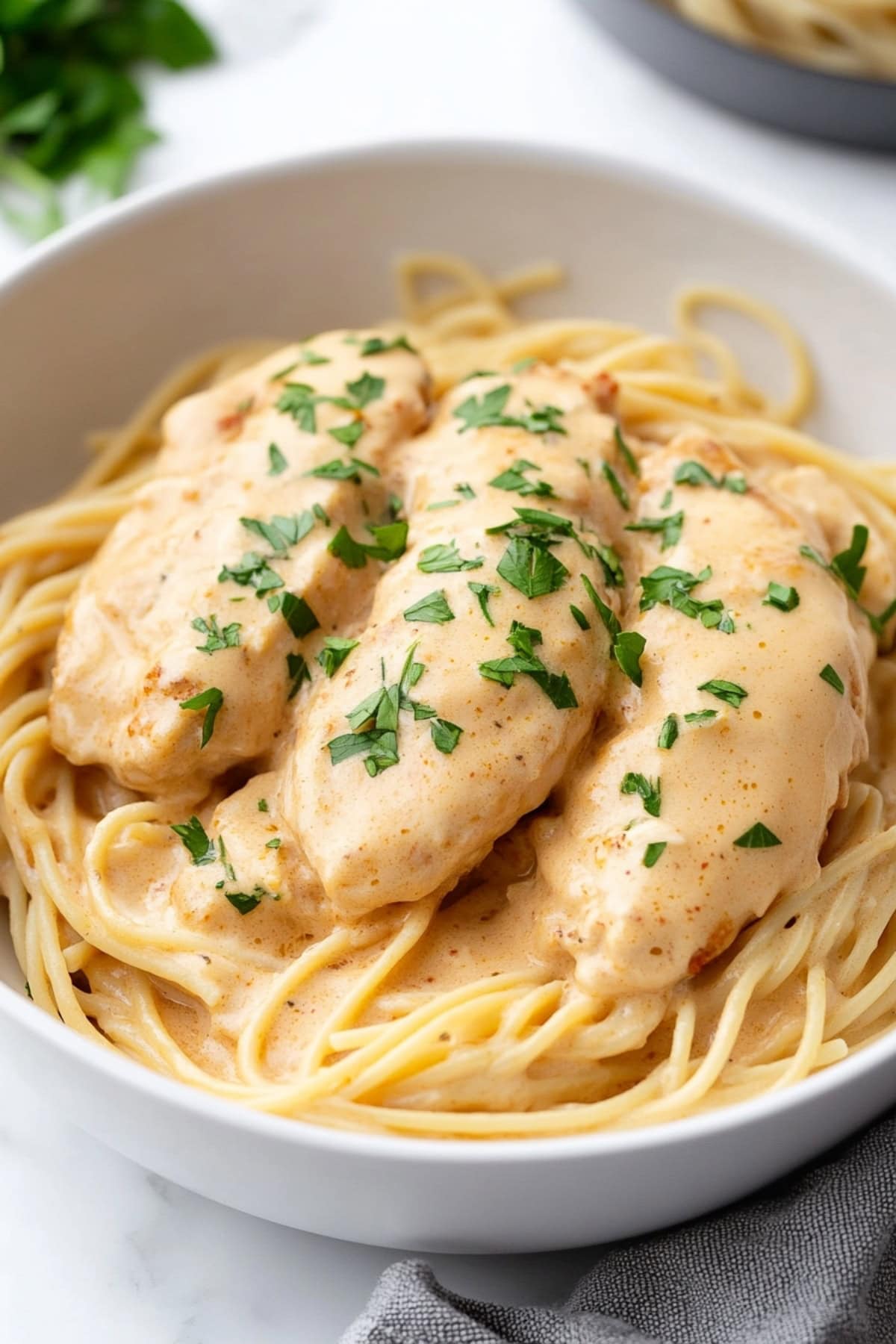 Creamy chicken lazone, sprinkled with parsley in a bowl.