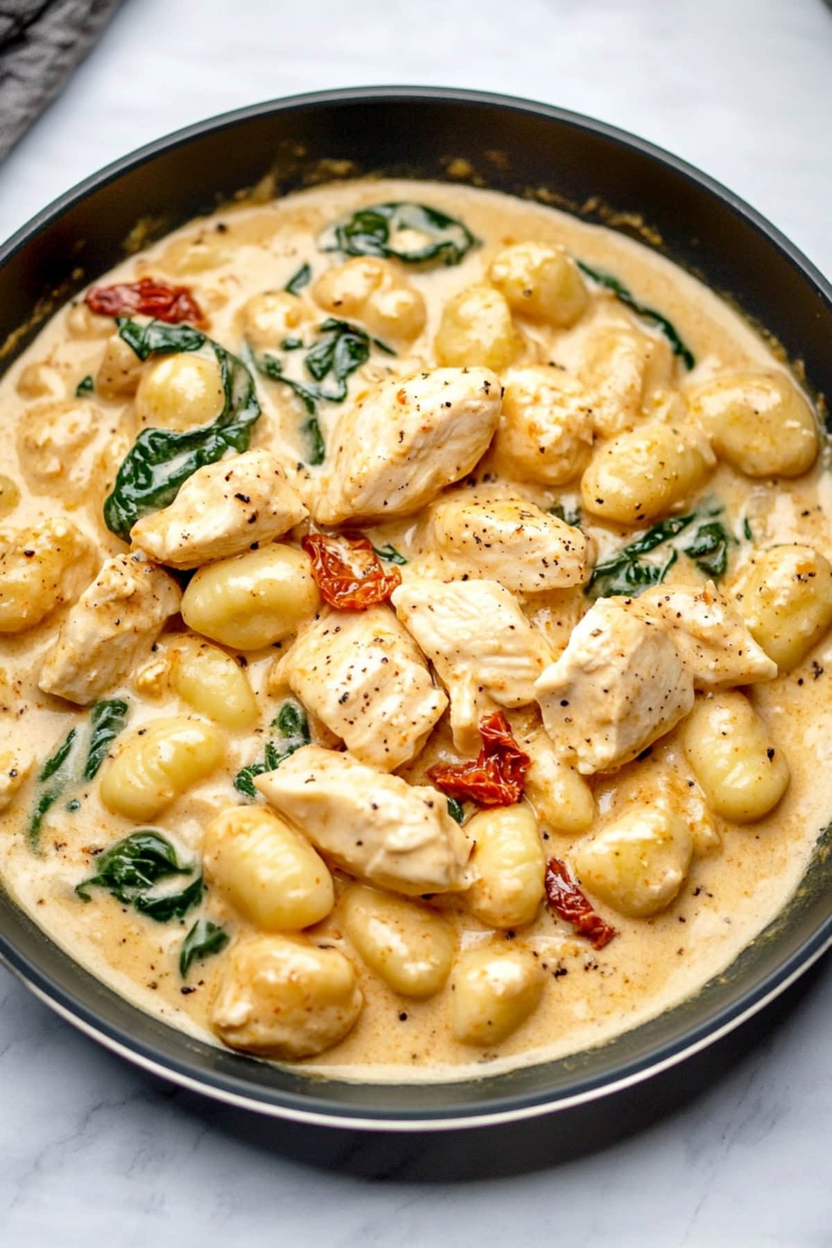 Creamy chicken and gnocchi in a rich sauce, sprinkled with parsley.