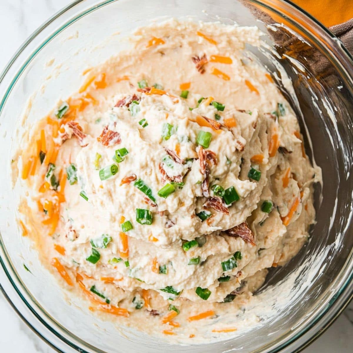 Cream cheese mixture with chopped dried beef in a glass mixing bowl.