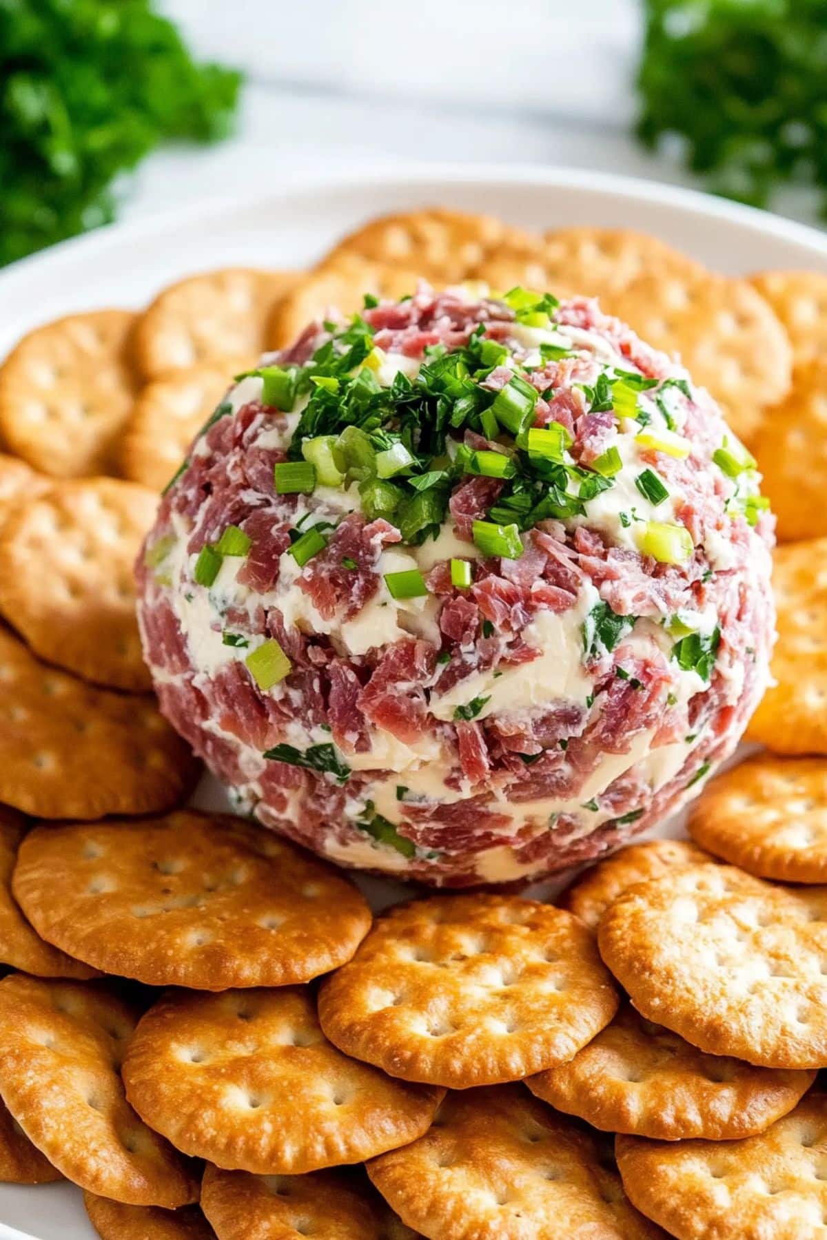 Dried beef cheese ball arranged in a platter of crackers. 