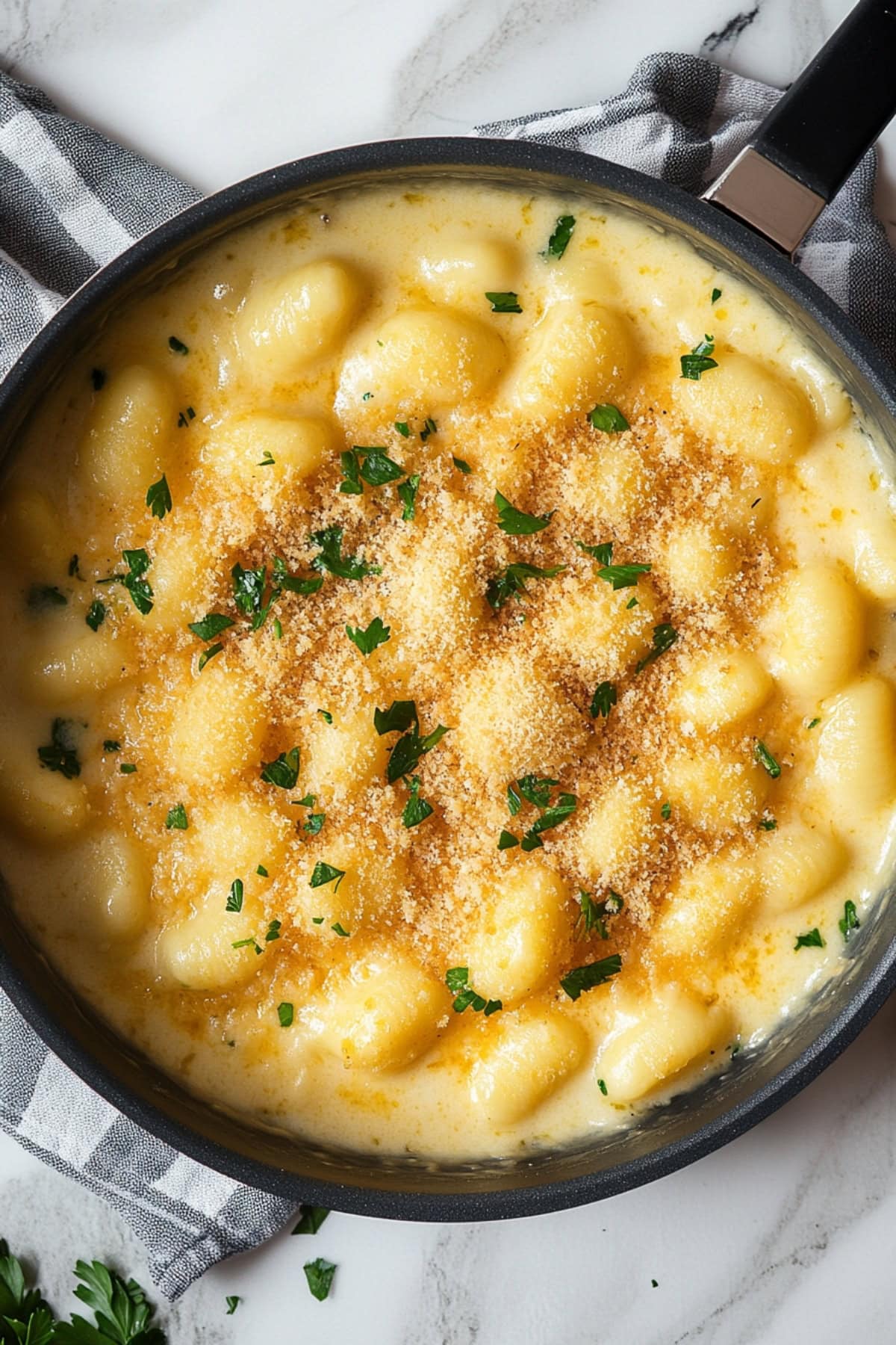 Creamy gnocchi mac & cheese, served in a skillet with a rich, cheesy sauce and a crispy baked topping, top view