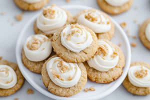 Bunch of graham cracker cookies with frosting arranged in a white plate.