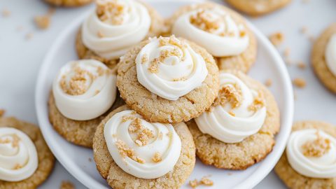 Bunch of graham cracker cookies with frosting arranged in a white plate.