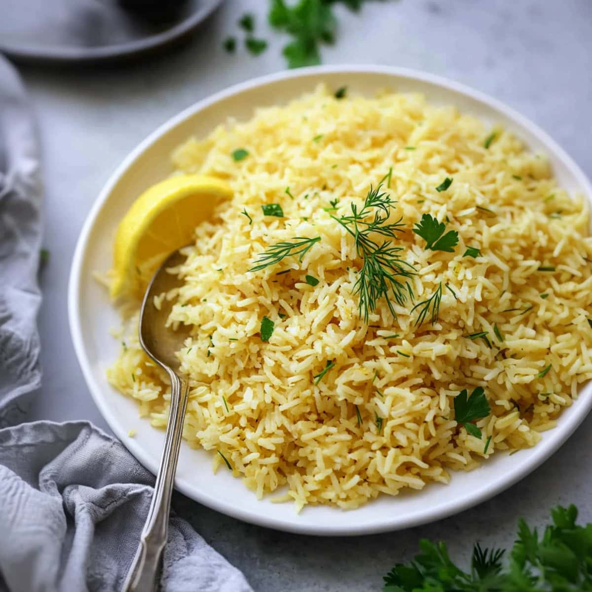 Close-up of fluffy lemon rice with a vibrant yellow hue, served on a white plate.