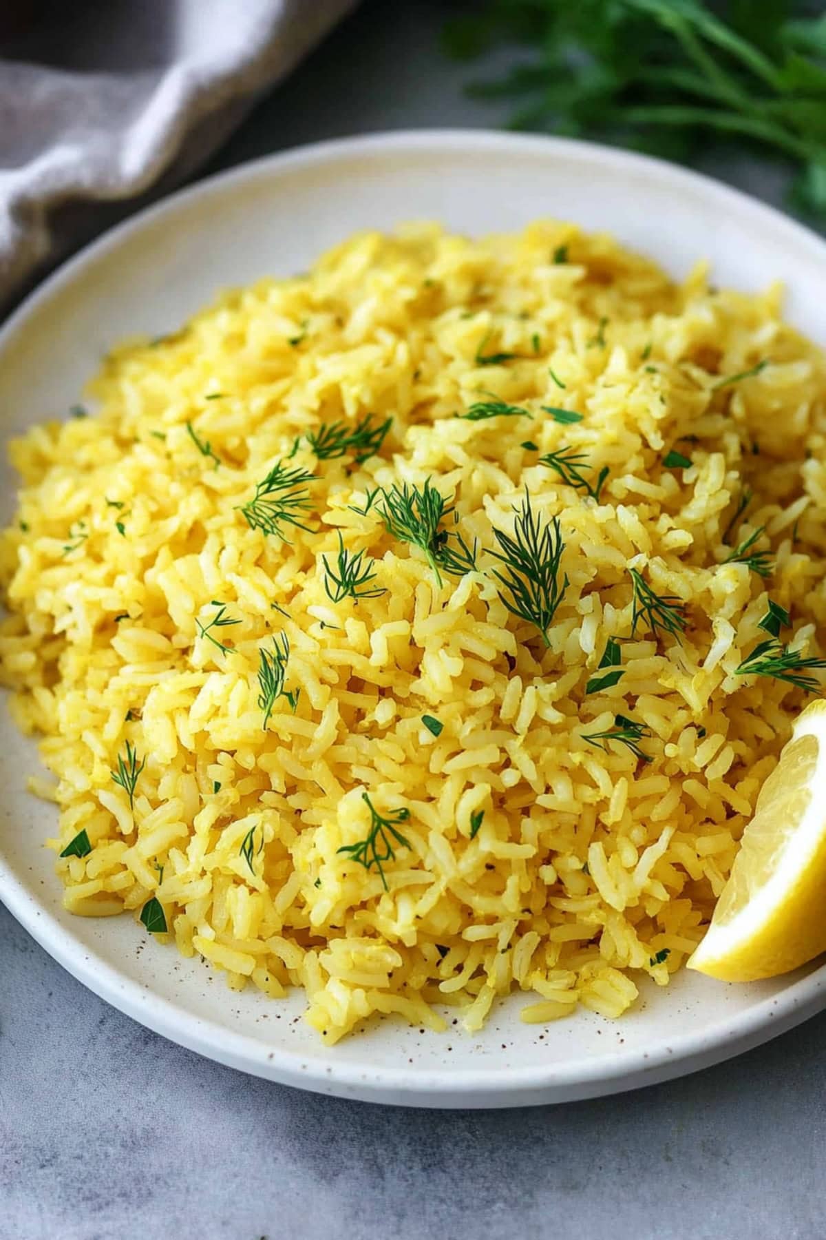 Greek lemon rice garnished with dill and a lemon wedge