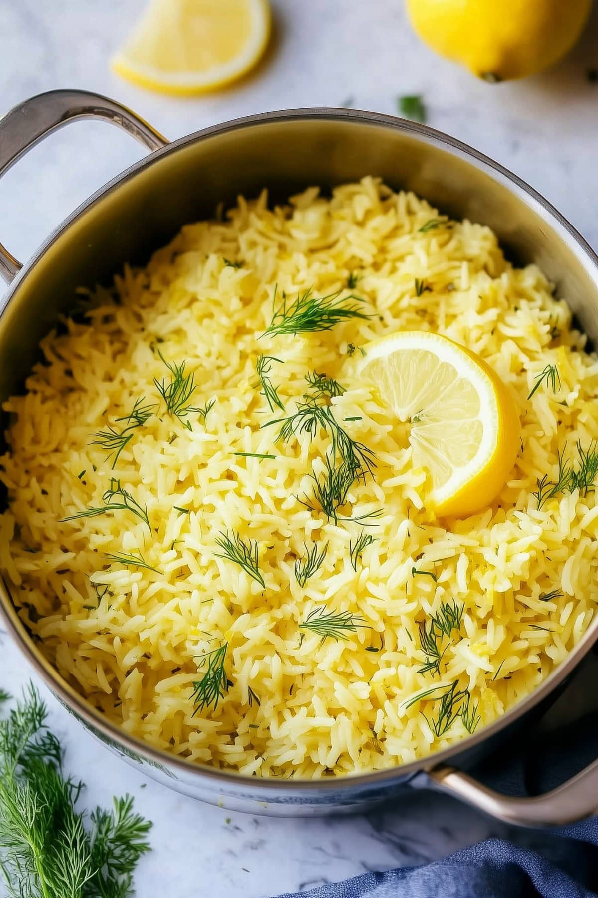 A pot of greek lemon rice with dill and fresh lemon, top view.