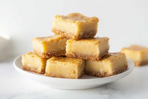 Creamy and delightful homemade chess squares with crust sitting in a plate.