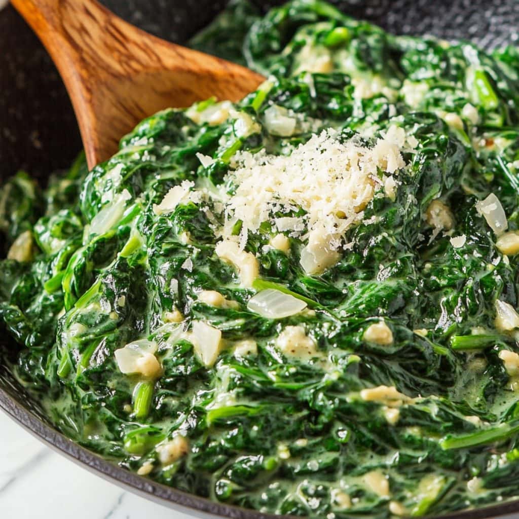 Homemade healthy creamed spinach with onions and garlic, sprinkled with parmesan cheese.