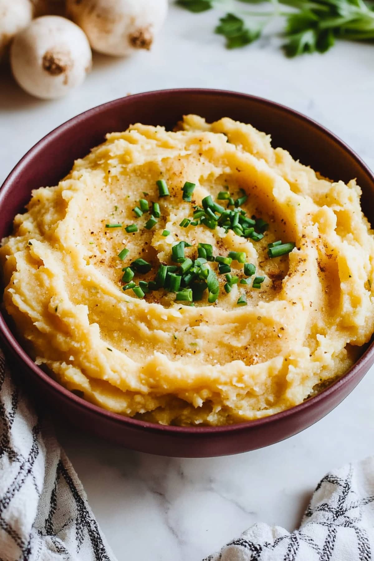 Rich and creamy mashed rutabaga with a soft, velvety texture, finished with fresh chives.