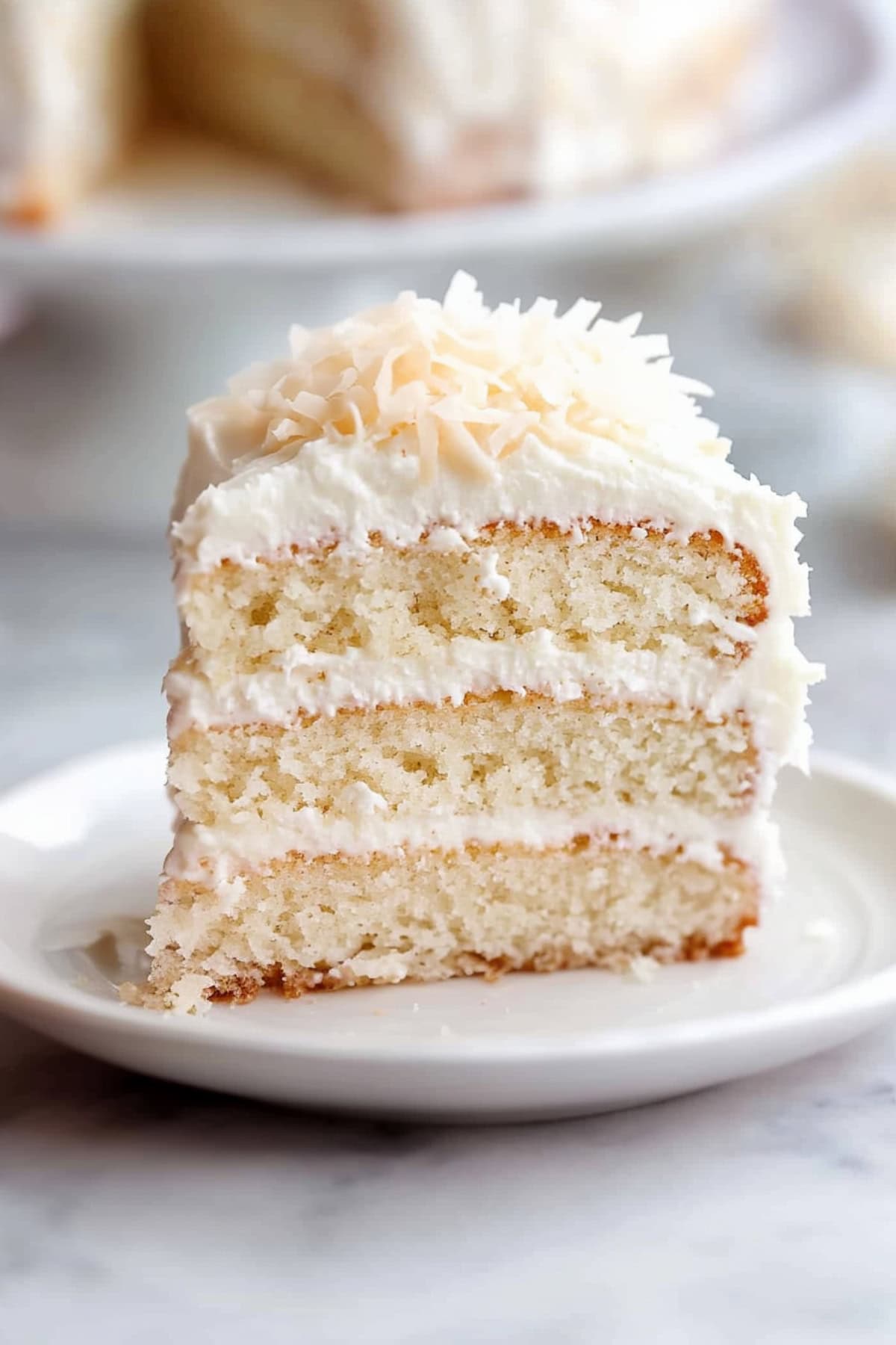 Sliced homemade coconut cake showing it's creamy filling.