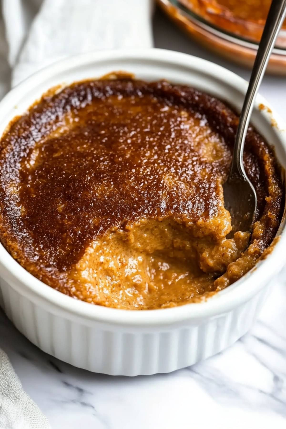 A serving of Indian pudding in a ramekin.