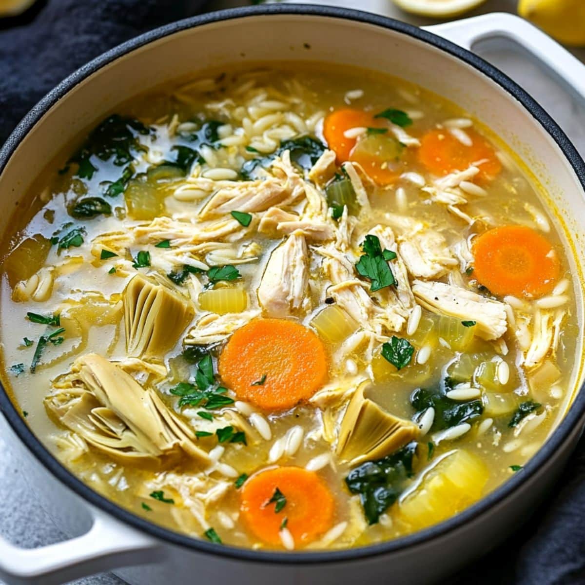 Lemon artichoke soup in a white pot. 