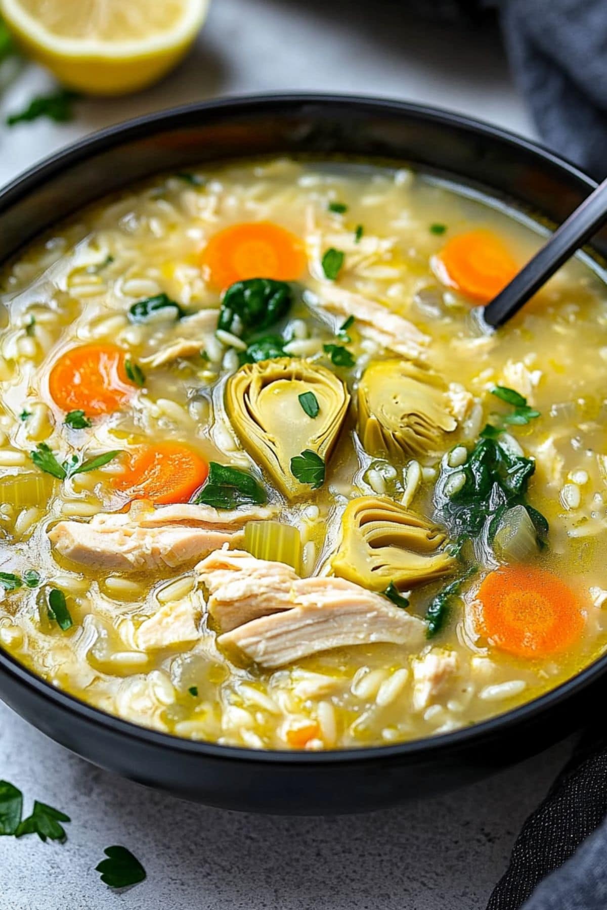 Lemon artichoke soup with lemony broth, chopped carrots, spinach and orzo pasta.