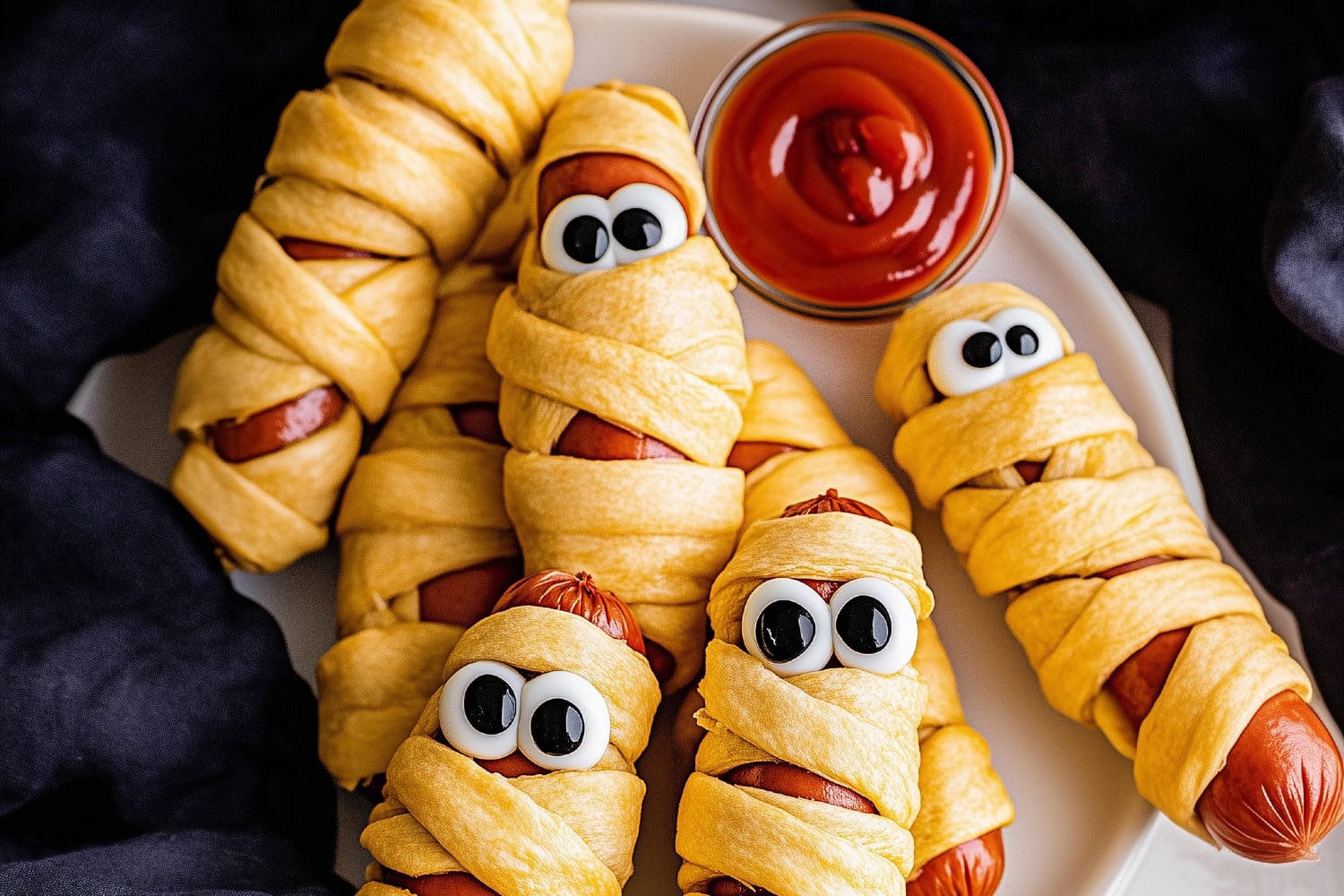 Hot dogs wrapped like mummies in puff pastry, their googly eyes peeking out from the layers.