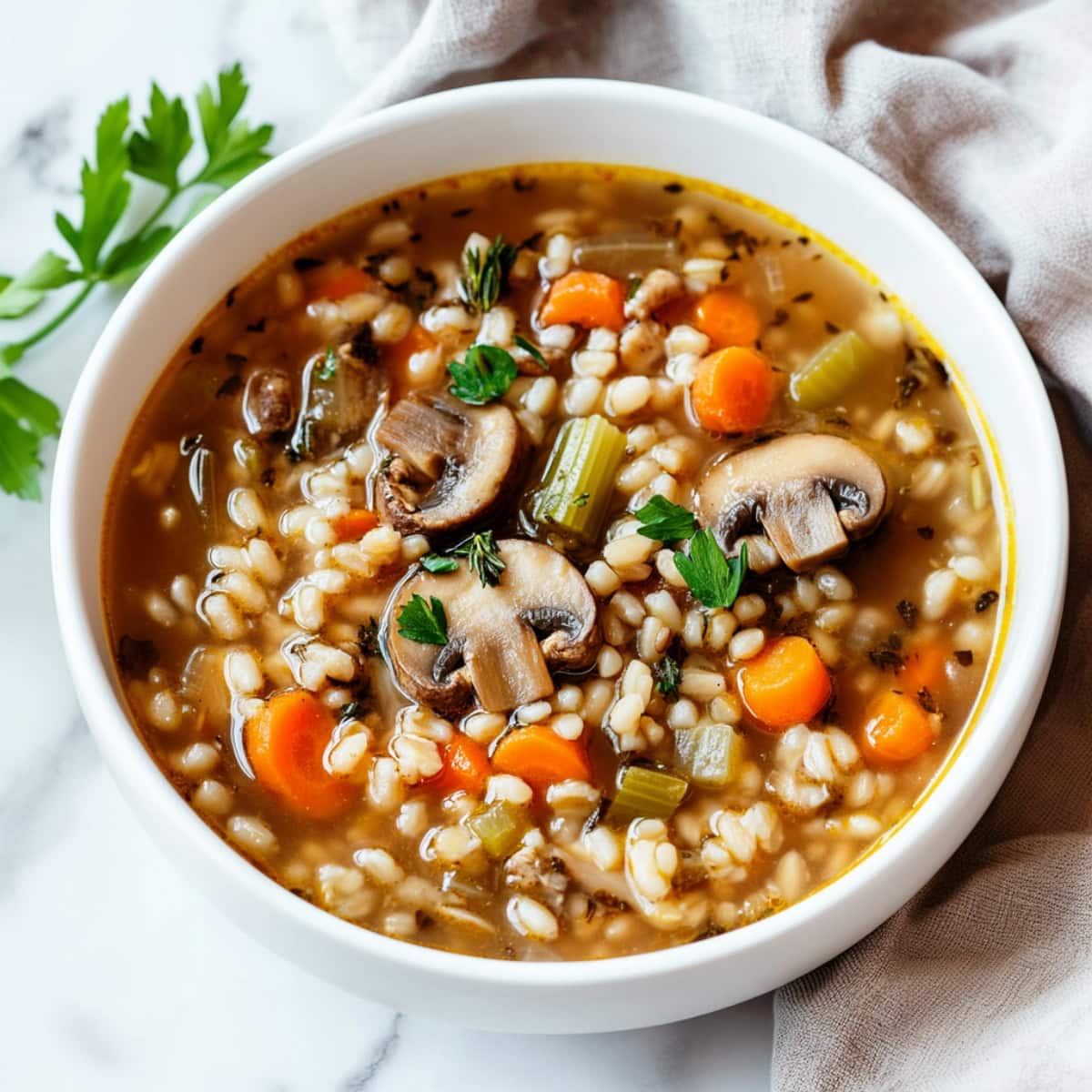 Warm mushroom barley soup with a mix of vegetable in a savory broth.