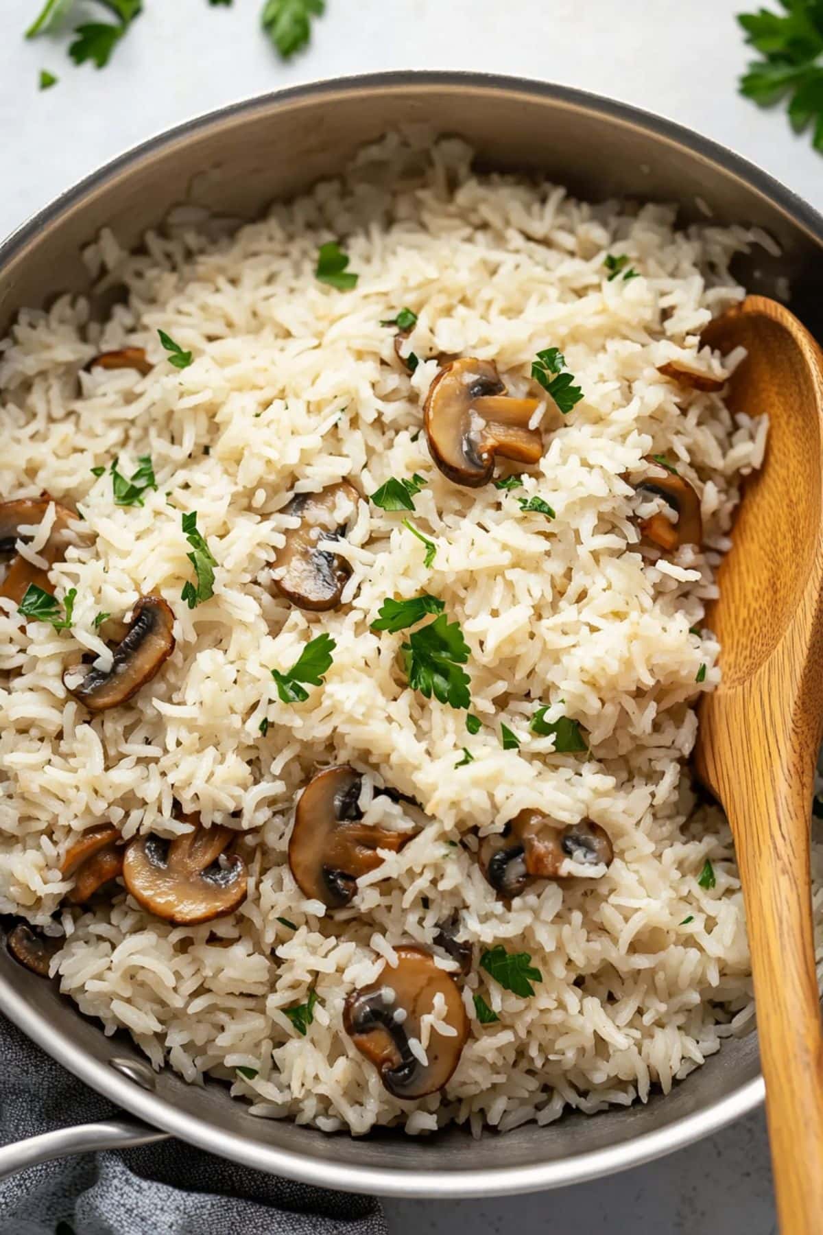 Mushroom rice tossed in a skillet pan with a wooden board,