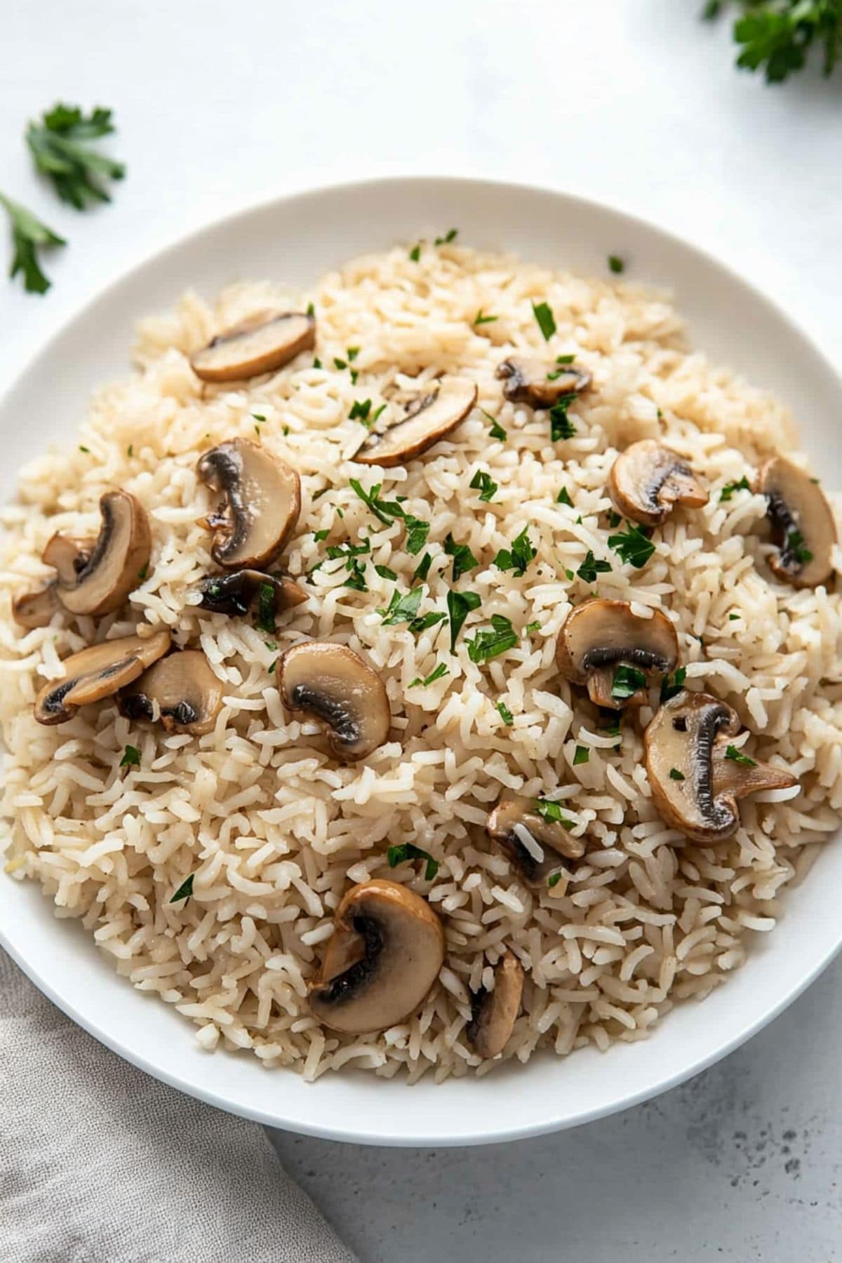 A platter of mushroom rice sitting on a white concrete table.