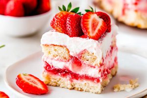 A square slice of no bake tiramisu garnished with slices of fresh strawberries.