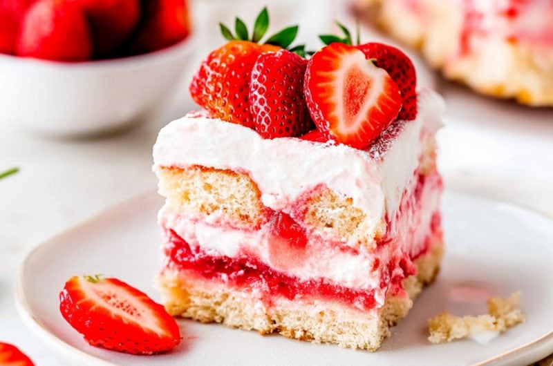 A square slice of no bake tiramisu garnished with slices of fresh strawberries.