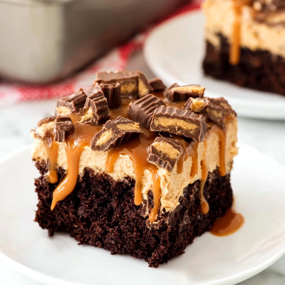 A slice of chocolate peanut butter poke cake square drizzled with caramel syrup.