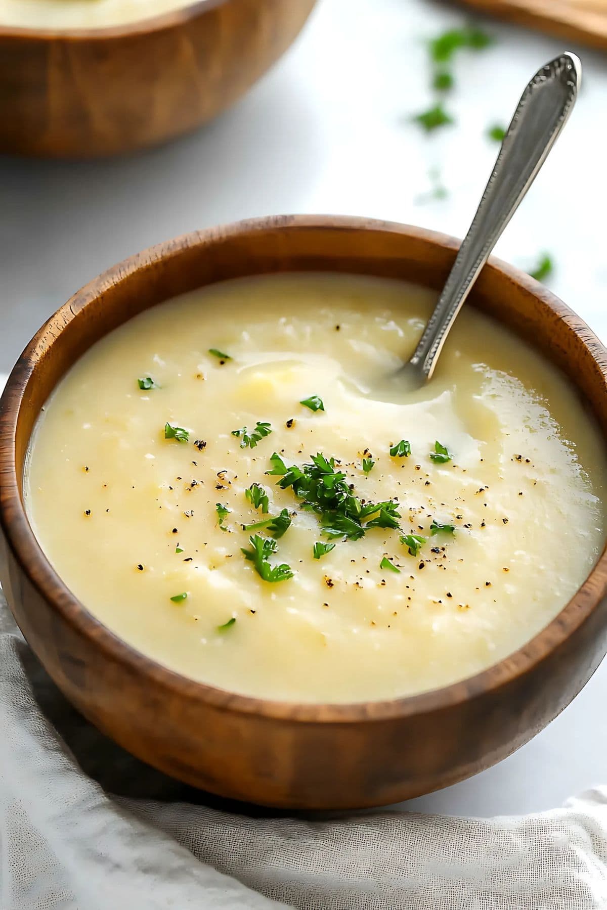 Creamy potato leek soup served in a wooden bowl.