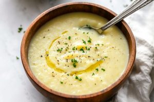 Potato leek soup served in a wooden bowl.