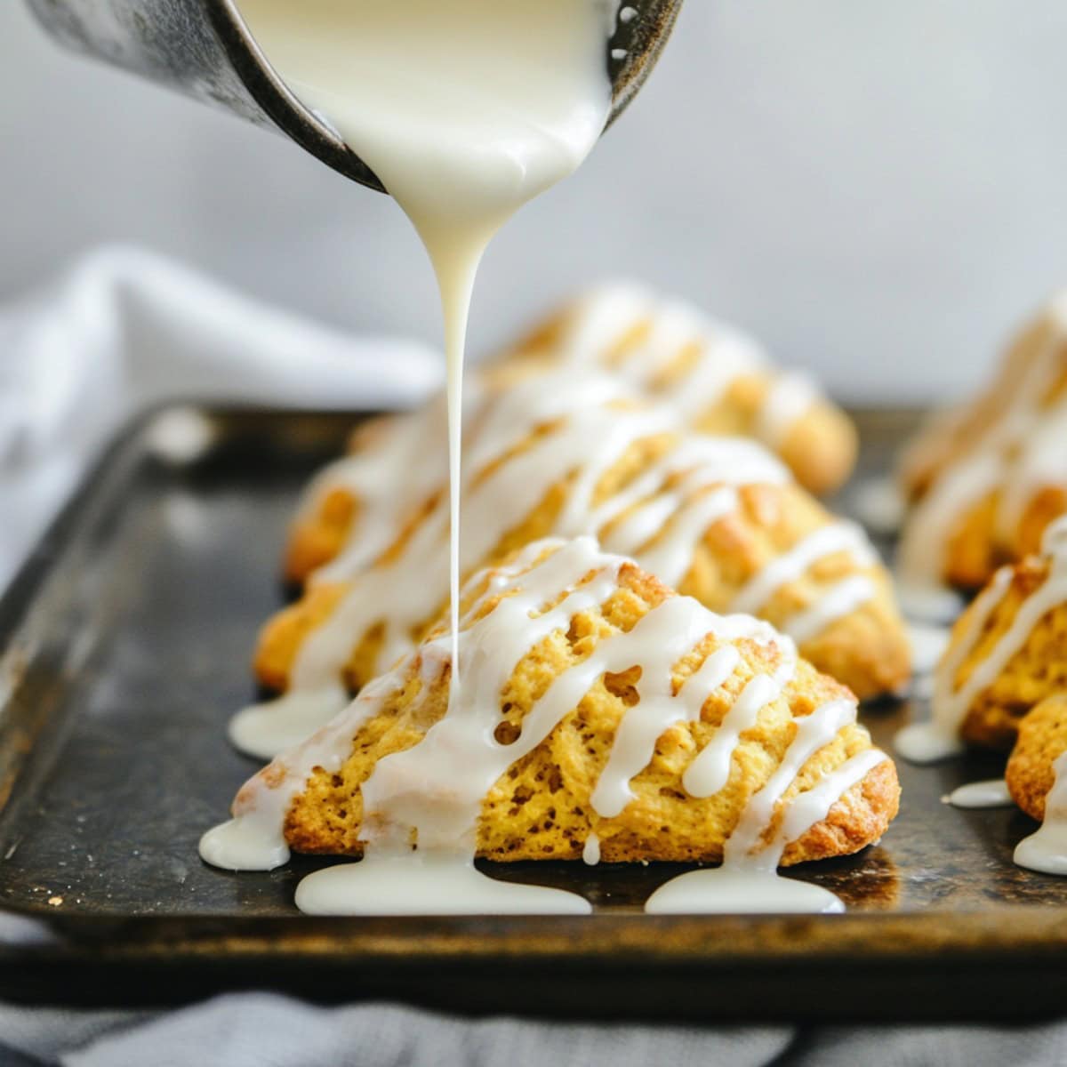 Pumpkin Scones Drizzled with Glaze on a Baking Tray