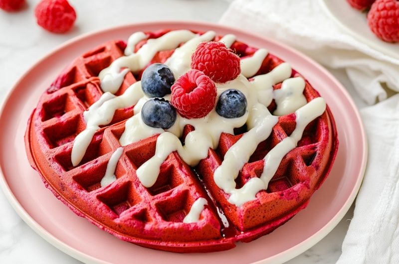 Soft and delicious homeamde red velvet waffles with cream cheese glaze and berries.