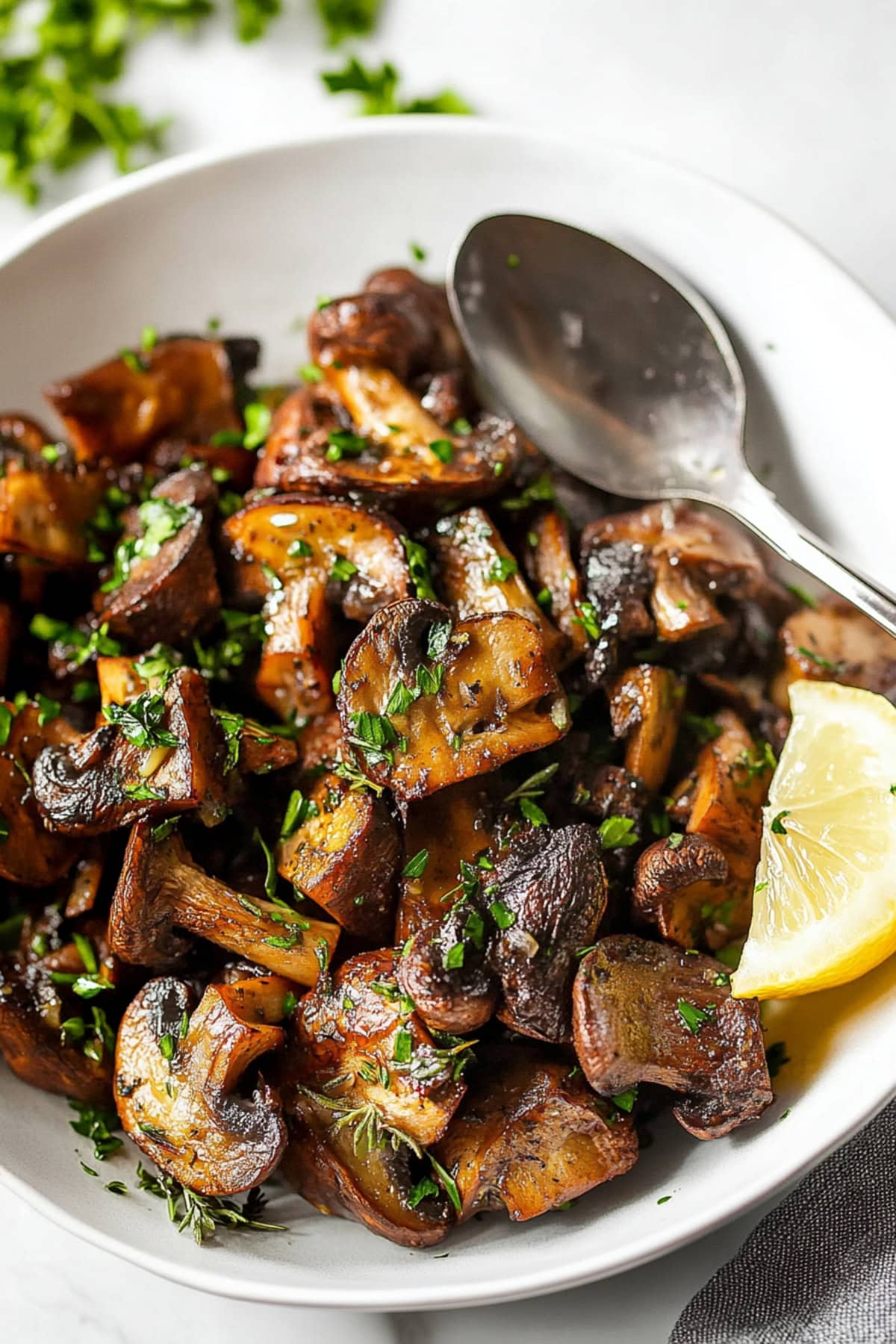 Homemade roasted mushrooms garnished with herbs and lemon wedge