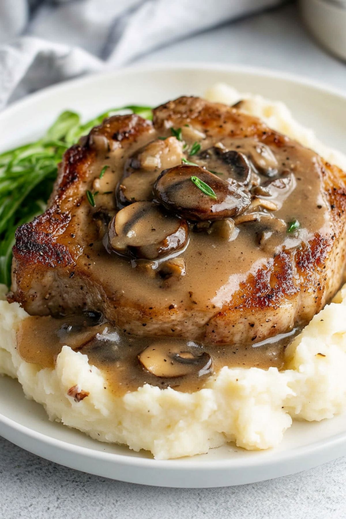 Mashed potatoes topped with porkchop and mushroom gravy.