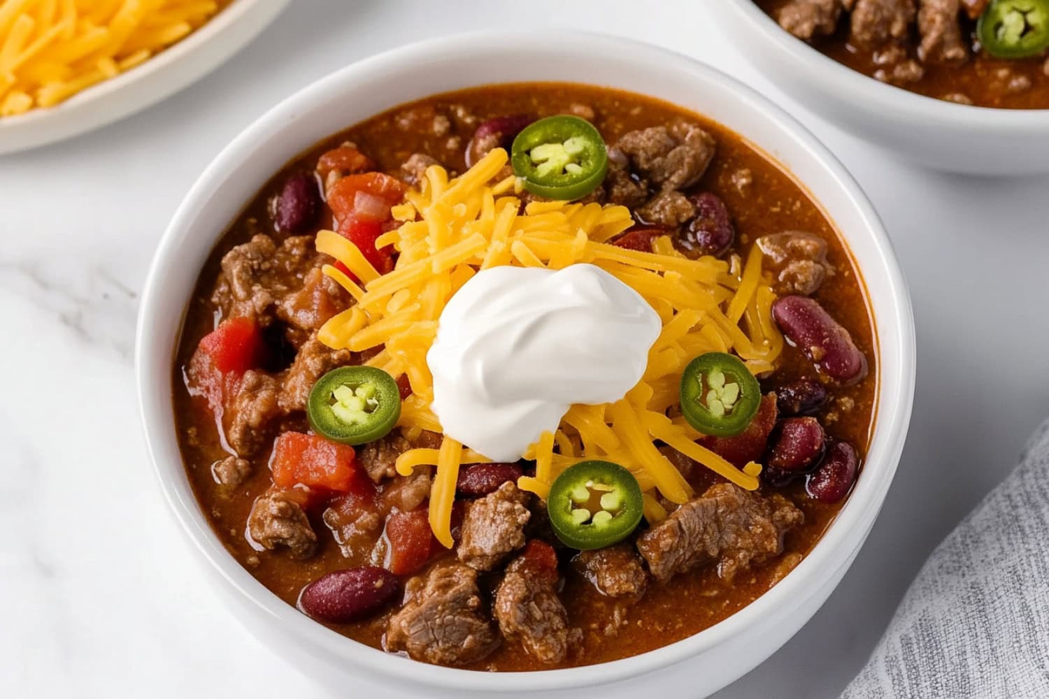 Rich and hearty steak chili in a white bowl.