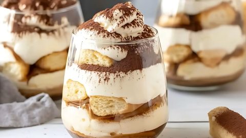 Tiramisu in glass cups dusted with cocoa powder on top,