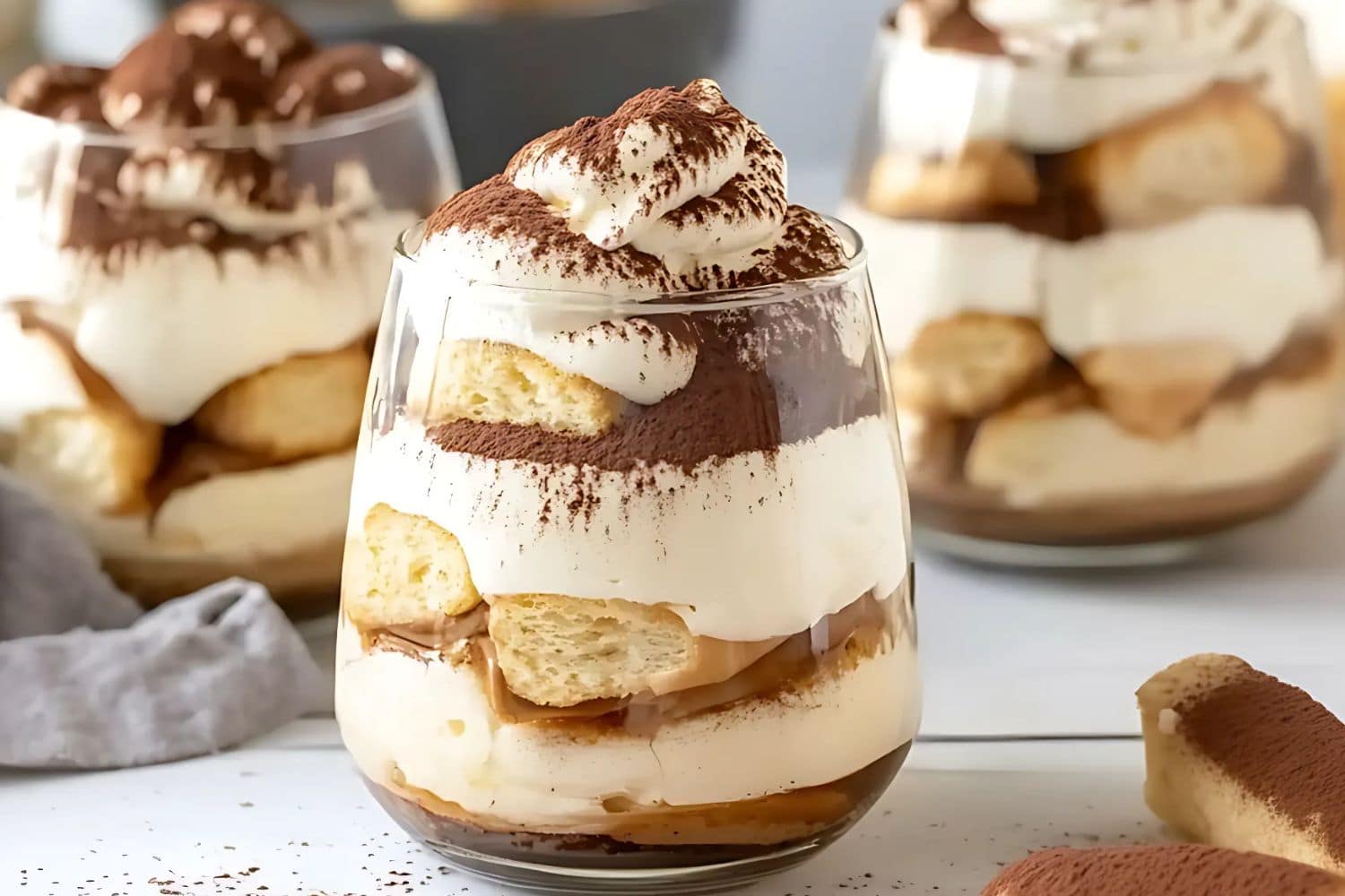 Tiramisu in glass cups dusted with cocoa powder on top,