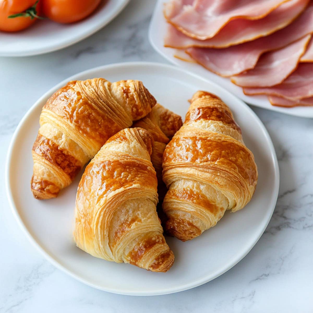 Bunch of croissant in a white plate.