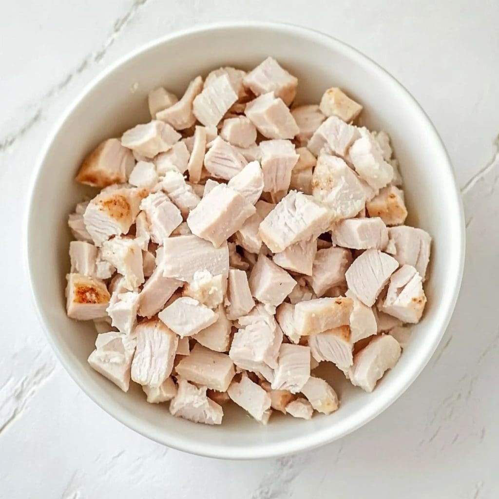 Cube sliced turkey in a white bowl.