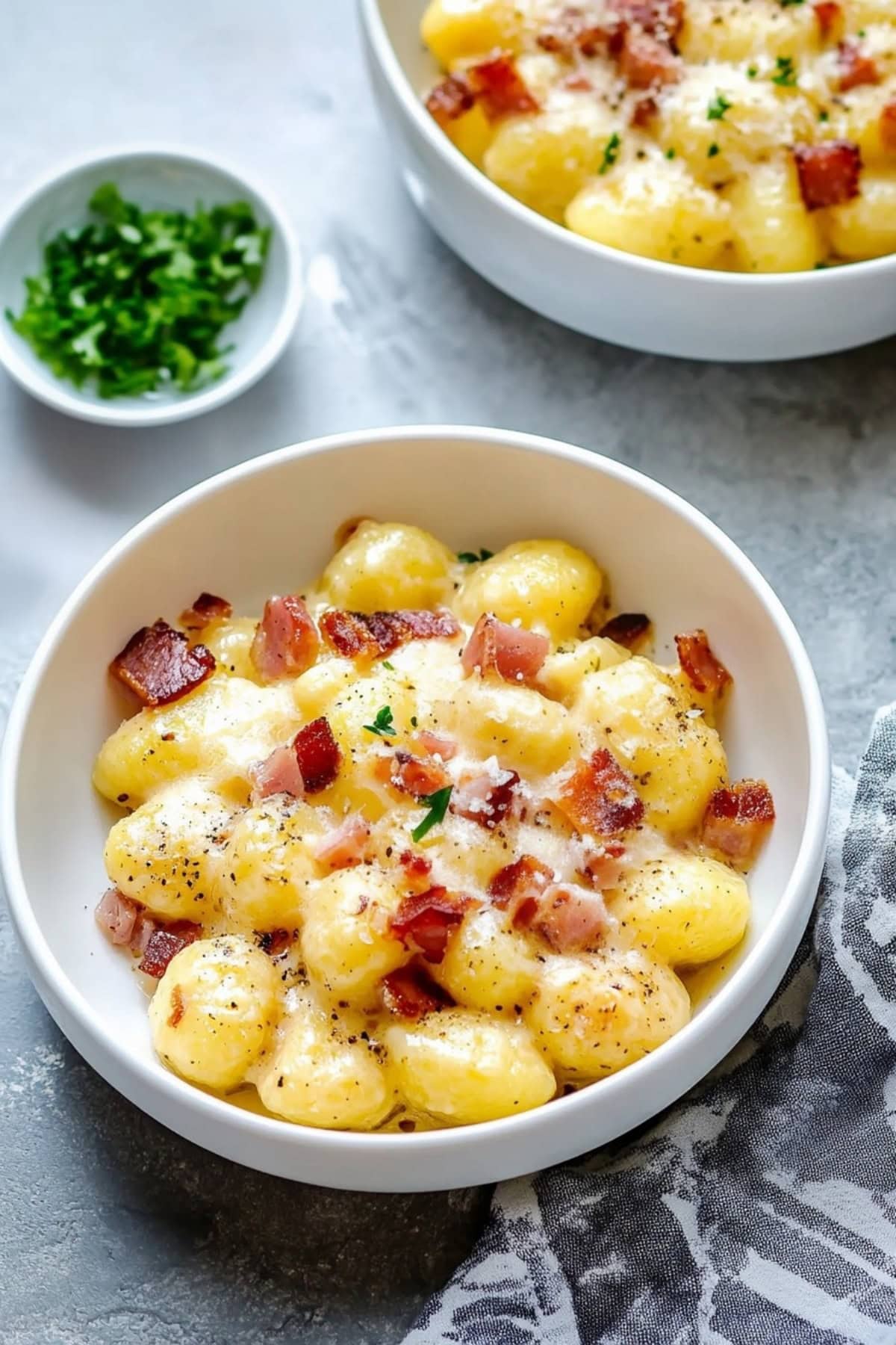 Golden gnocchi pieces coated in carbonara sauce, served with crumbled pancetta.