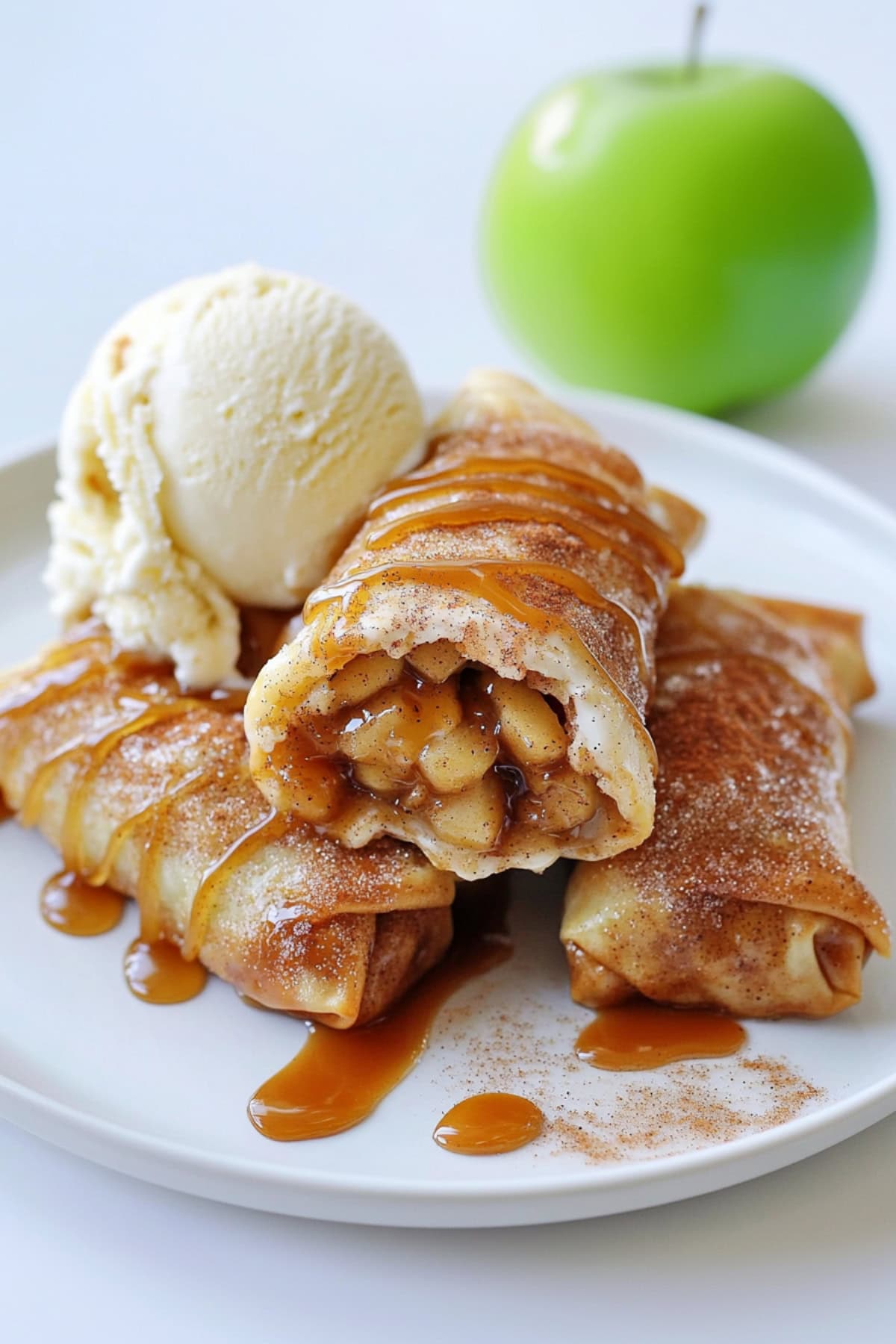 Apple Pie Egg Rolls on a plate with caramel and ice cream