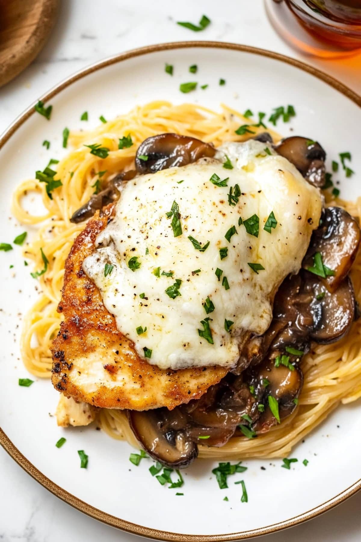 Chicken lombardy served  on top of fettucine noodles with creamy sauce on top.