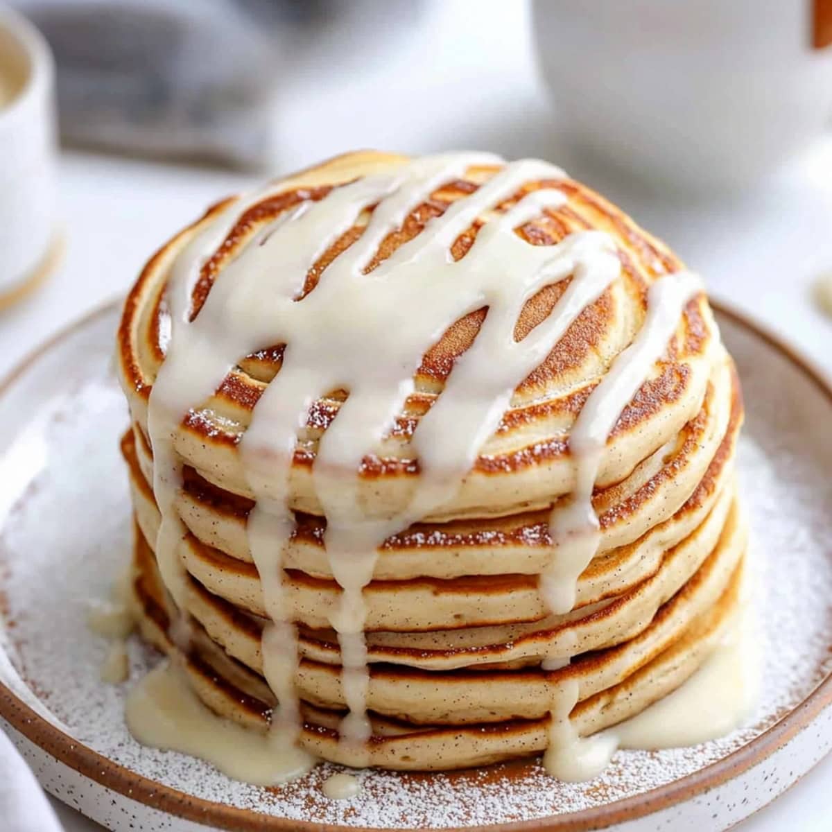 Fluffy cinnamon pancake on a plate with sweet glaze drizzled on top