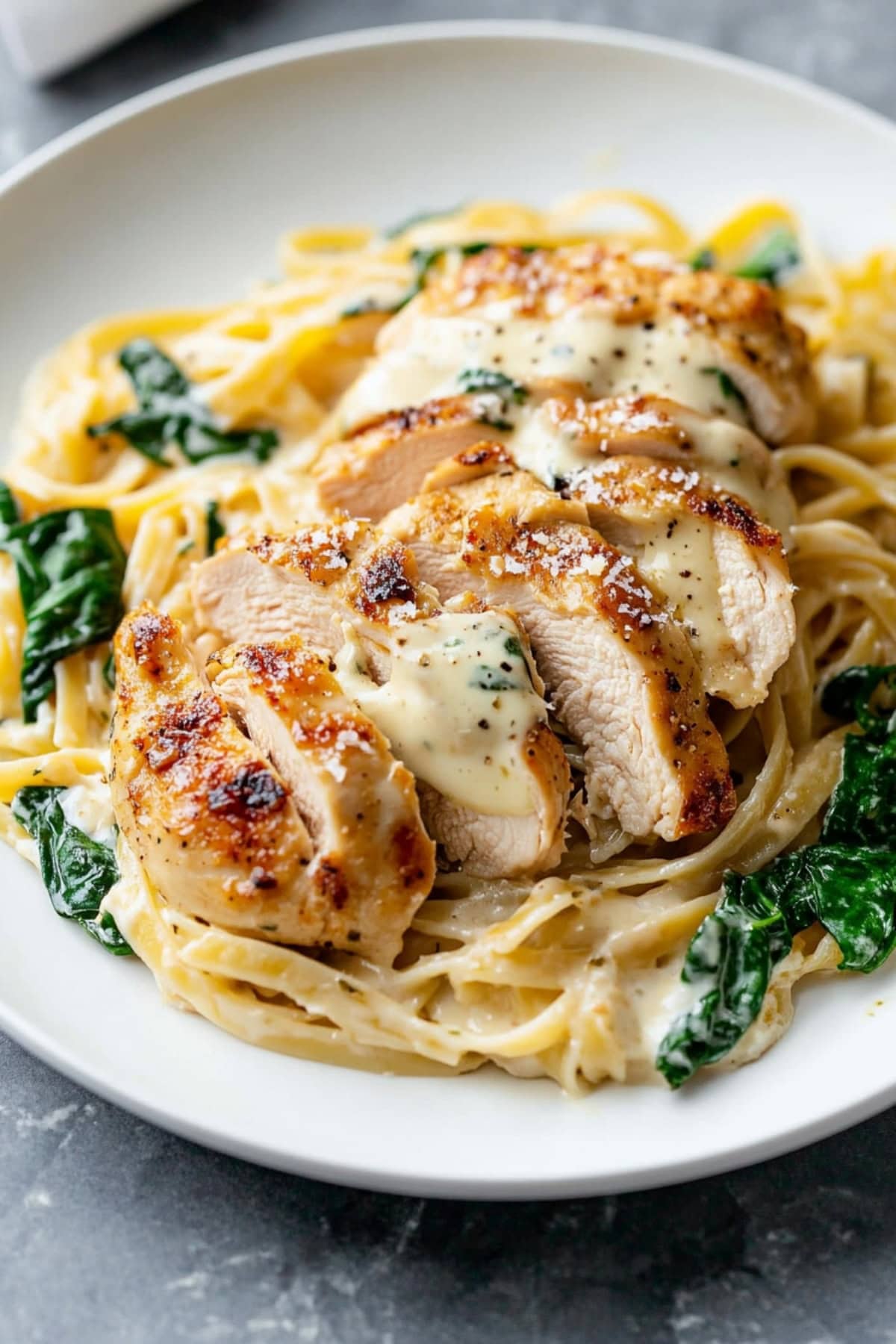 Sliced creamy chicken Florentine served with pasta.