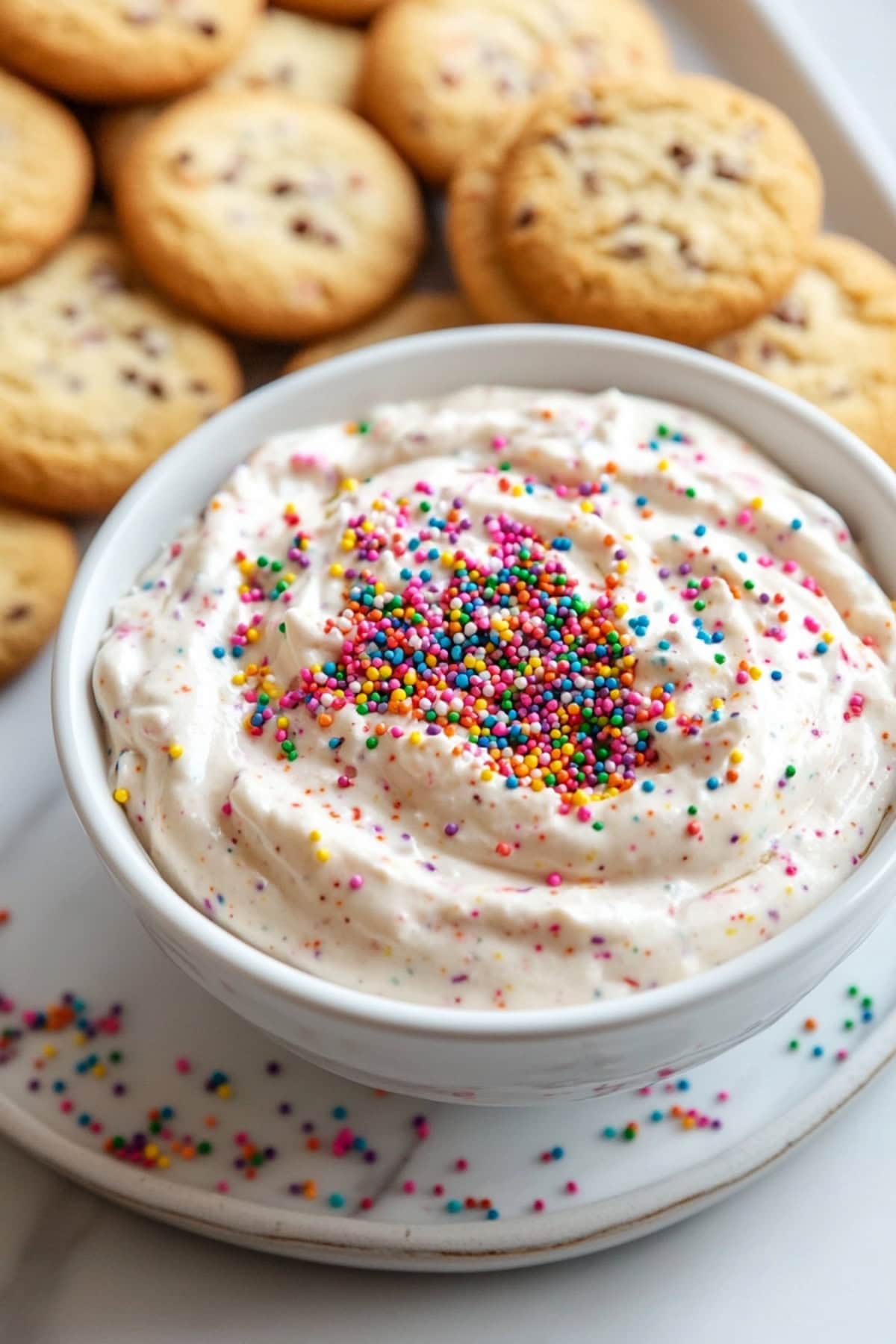 Dunkaroo dip in a white bowl with cookies on the side, top view.