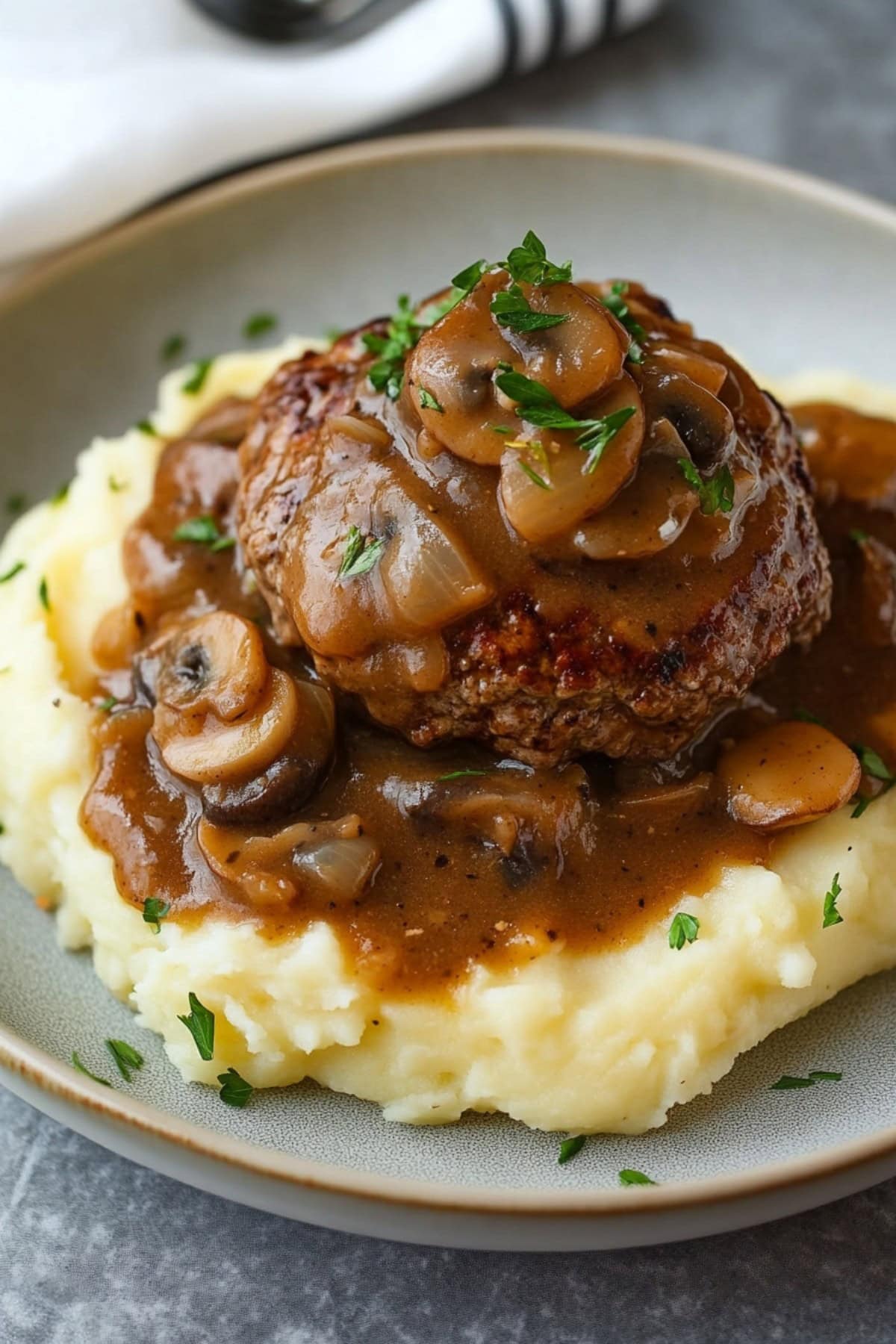 Hamburger steak with mashed potatoes in a plate.