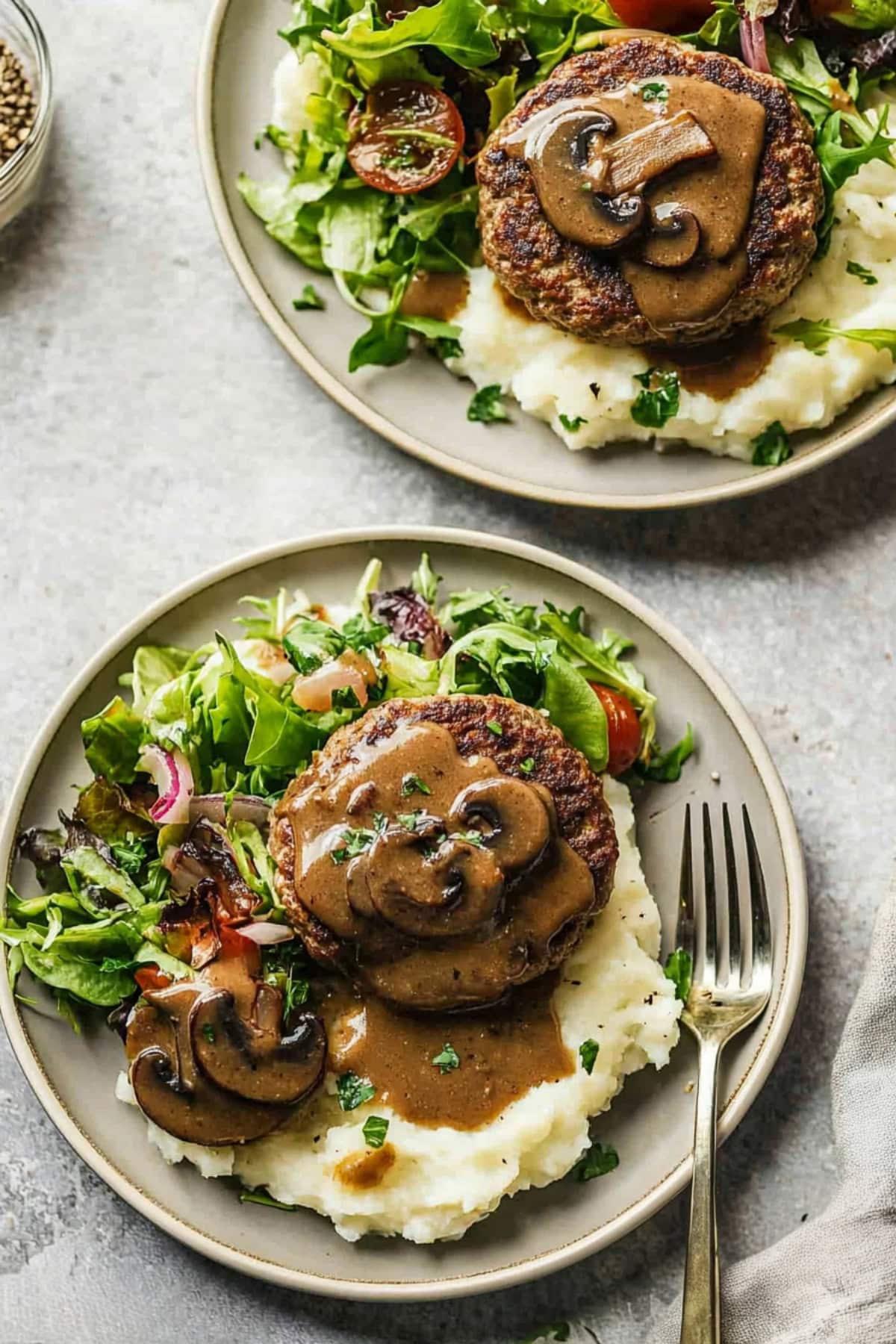 Savory homemade hamburger steak with vegetable salad and mashed potatoes.