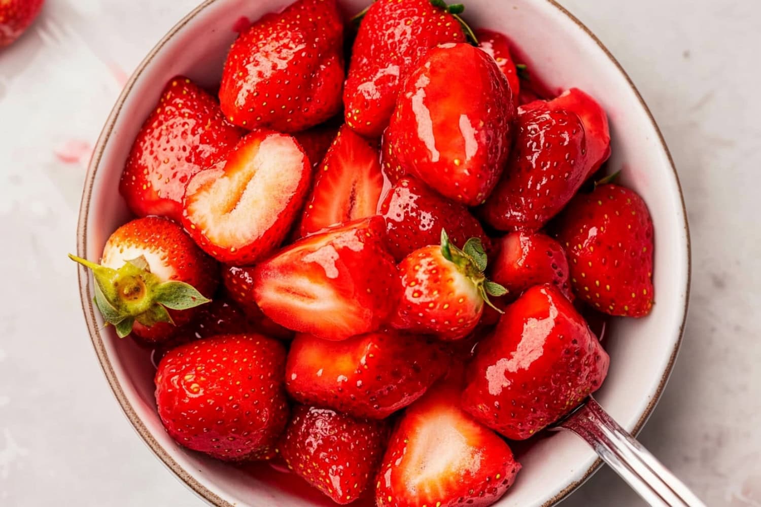 Macerated strawberries in a white bowl.