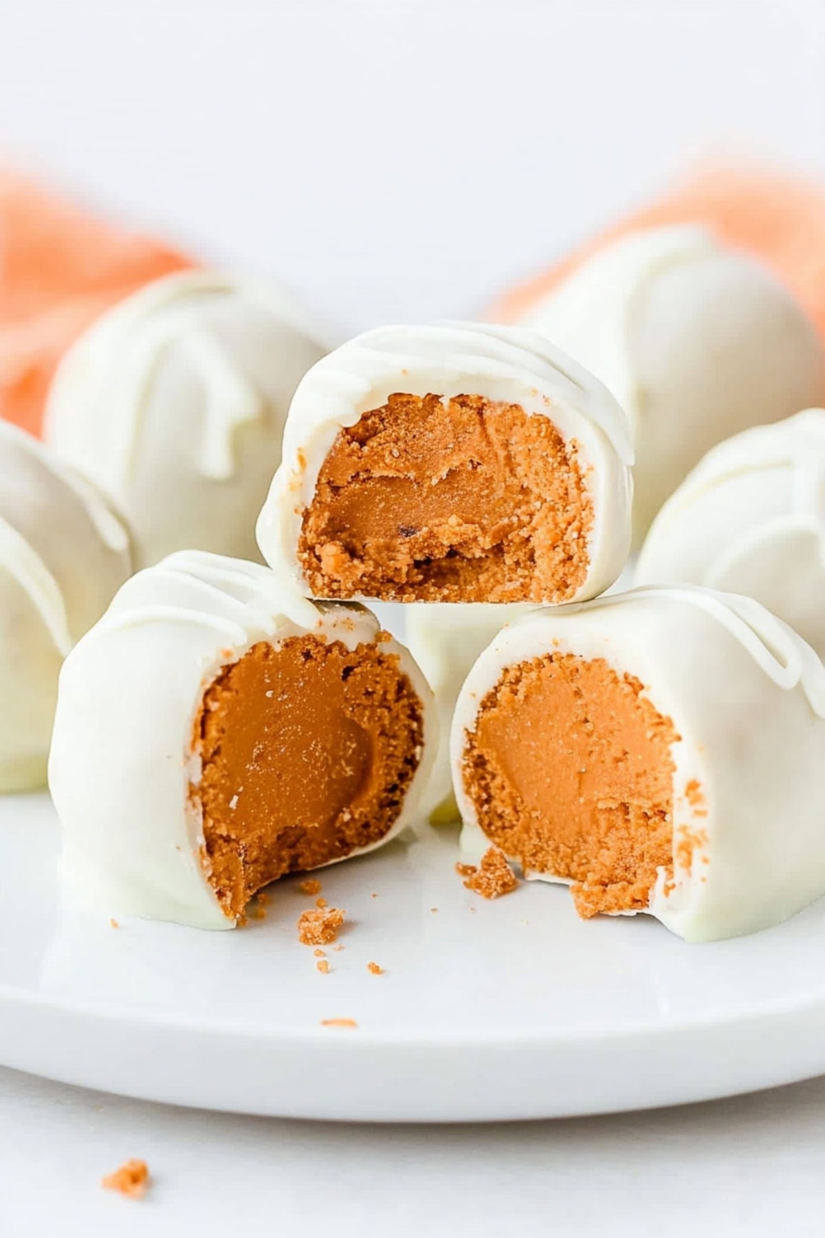 A dessert plate featuring no-bake pumpkin cheesecake bites with drizzles of white chocolate for extra sweetness.