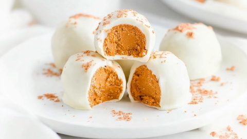 A plate of creamy no-bake pumpkin cheesecake balls with a hint of cinnamon.