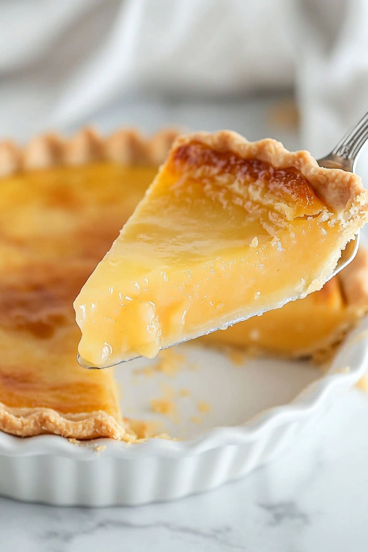 Whole Old Fashioned Vinegar Pie with a slice held up